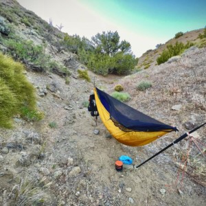 Sheltered from the frigid hard winds in a gully past the Aquaduct in a wind farm. Loose soil was a challenge, but all held after judicious probing to place anchors behind large subterranean rocks.